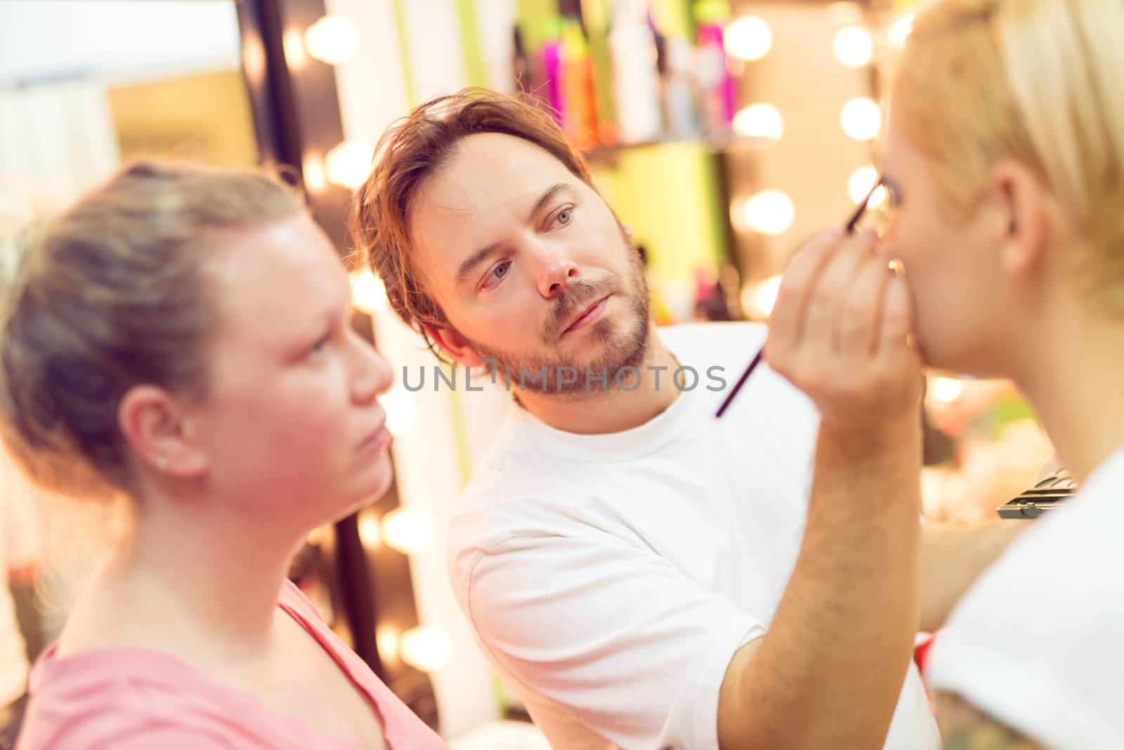 Makeup teacher helping students training to become makeup artist.