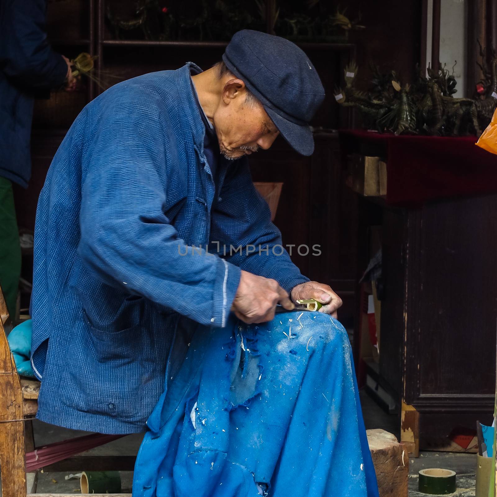 ZHOUZHUANG, SHANGHAI - April 11, 2011 : Zhouzhuang, the ancient water village is Shanghai tourist attraction with 1,000,000 visitors per year and there are a lot of variety activities have done here, in this image, the old Craftman is working
