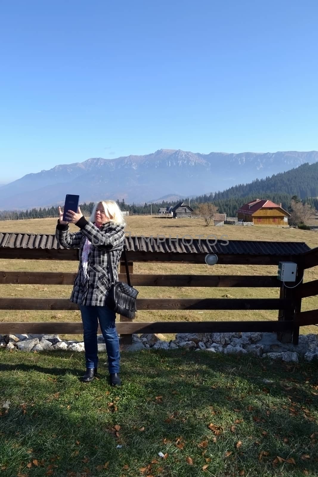 Houses in the mountains and a wooden fence.
Mari take pictures for the family album