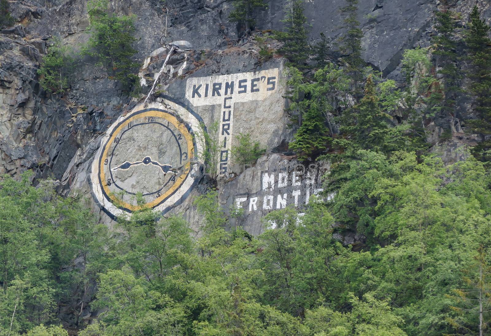 Skagway, Alaska, USA-June 18, 2012: Rock Clock is a large painting on the cliff of a hillside in Skagway. This was first painted during the gold rush era in Alaska.