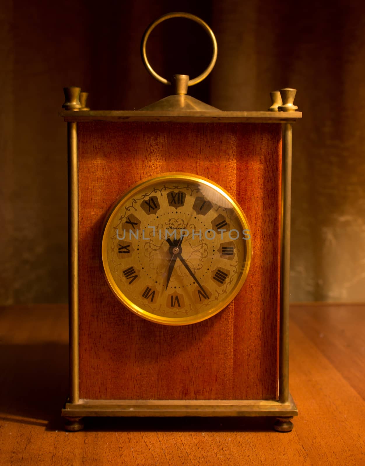old table clock on a table in a warm light