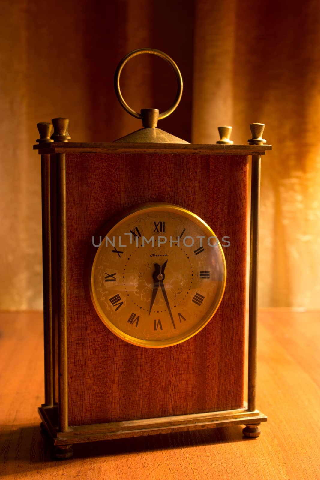 old table clock on a table in a warm light