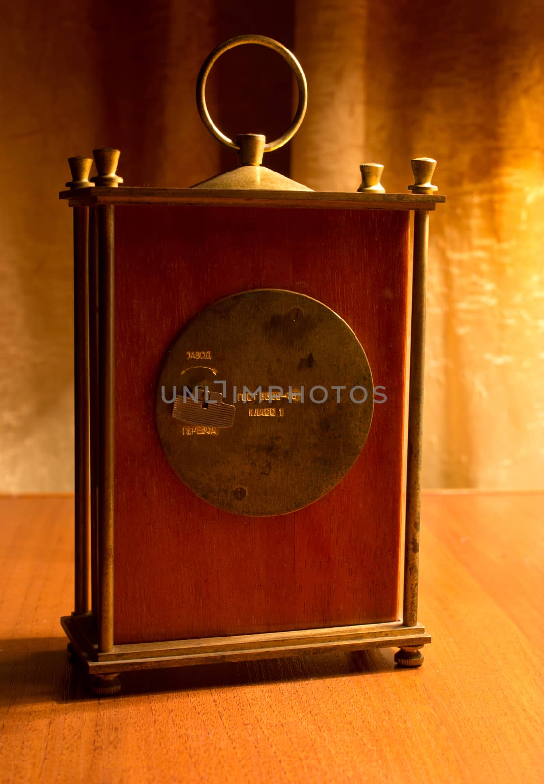 back side clock on wooden table, warm light