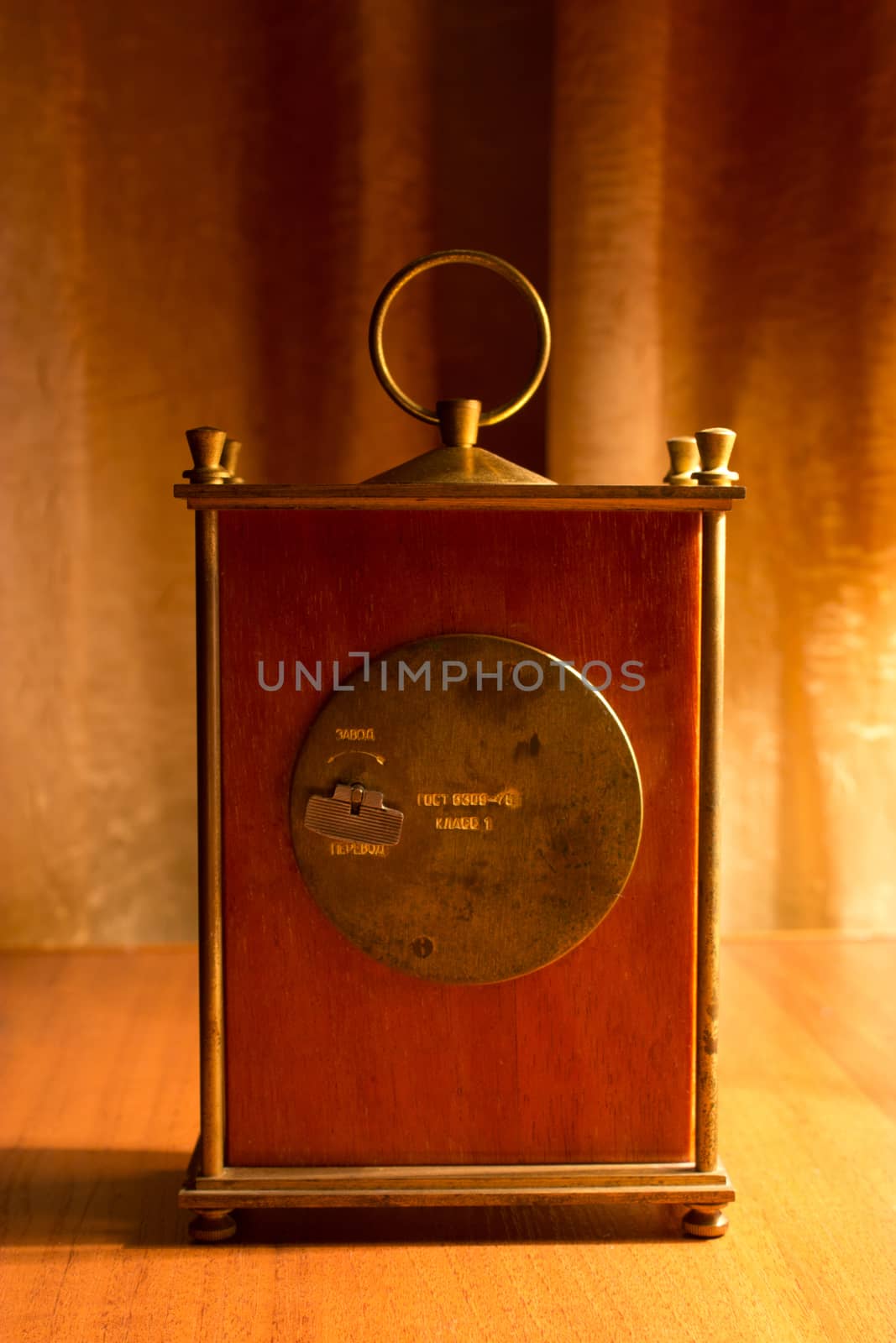 back side clock on wooden table, warm light