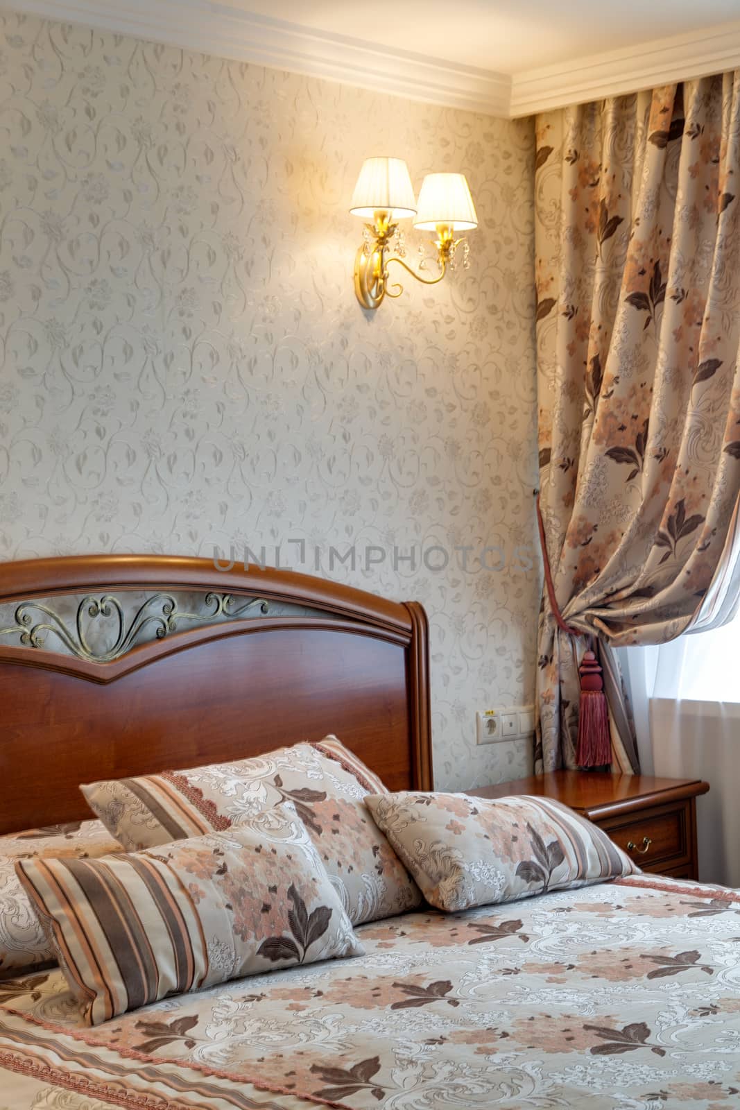 Bedroom in hotel with a big bed, a bedside table and a window