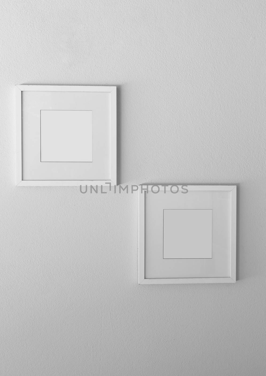 Blank white picture frame on white wall