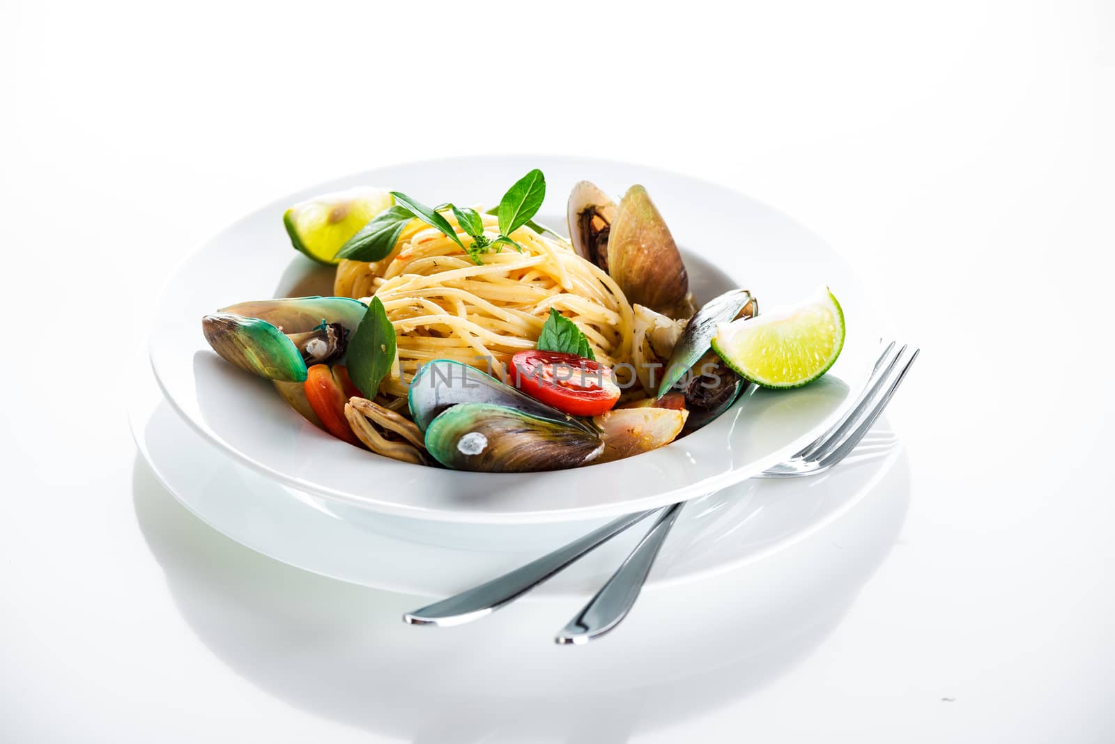 Fresh and spicy seafood pasta in white plate on white background
