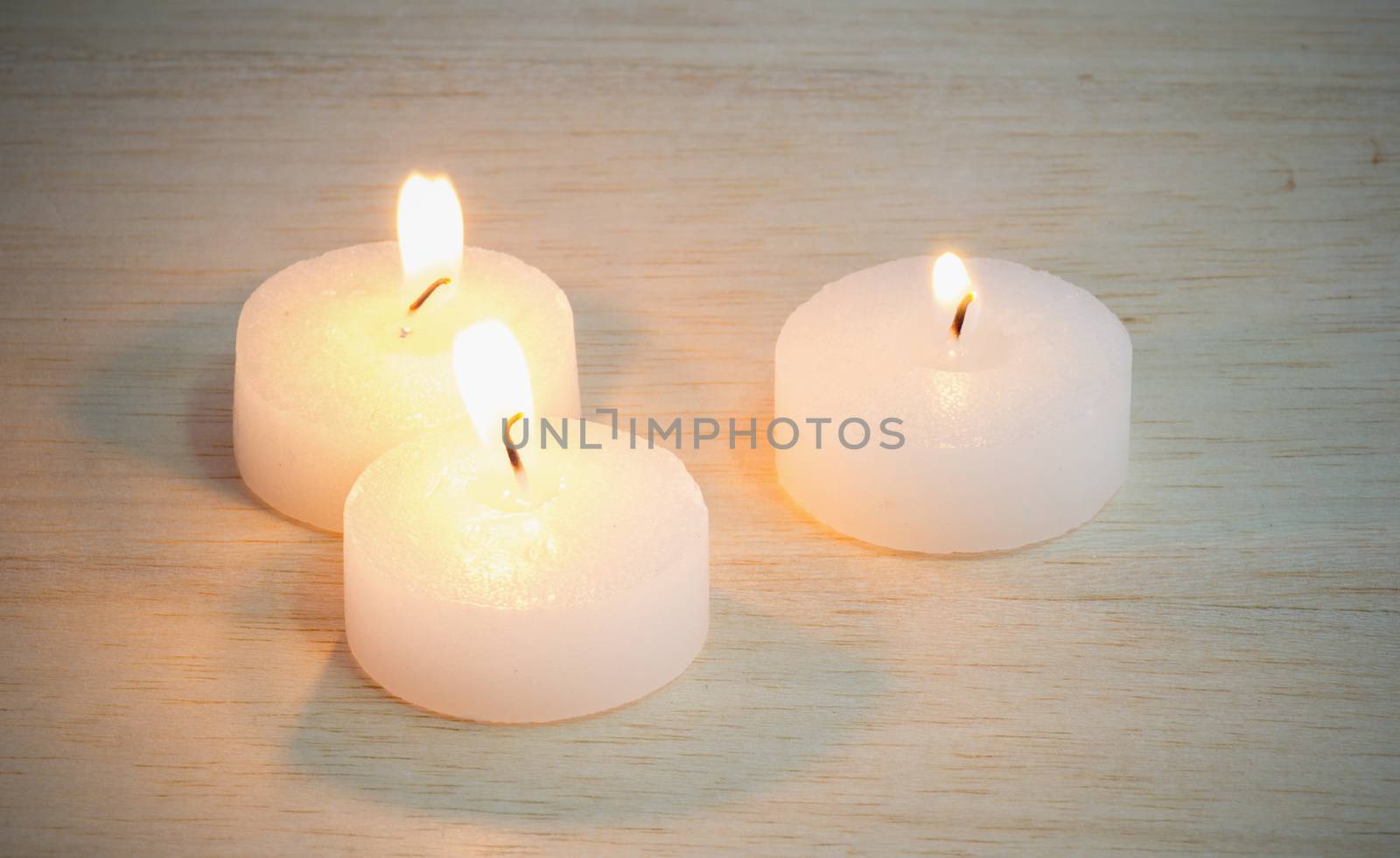 candle on wood background by chingraph