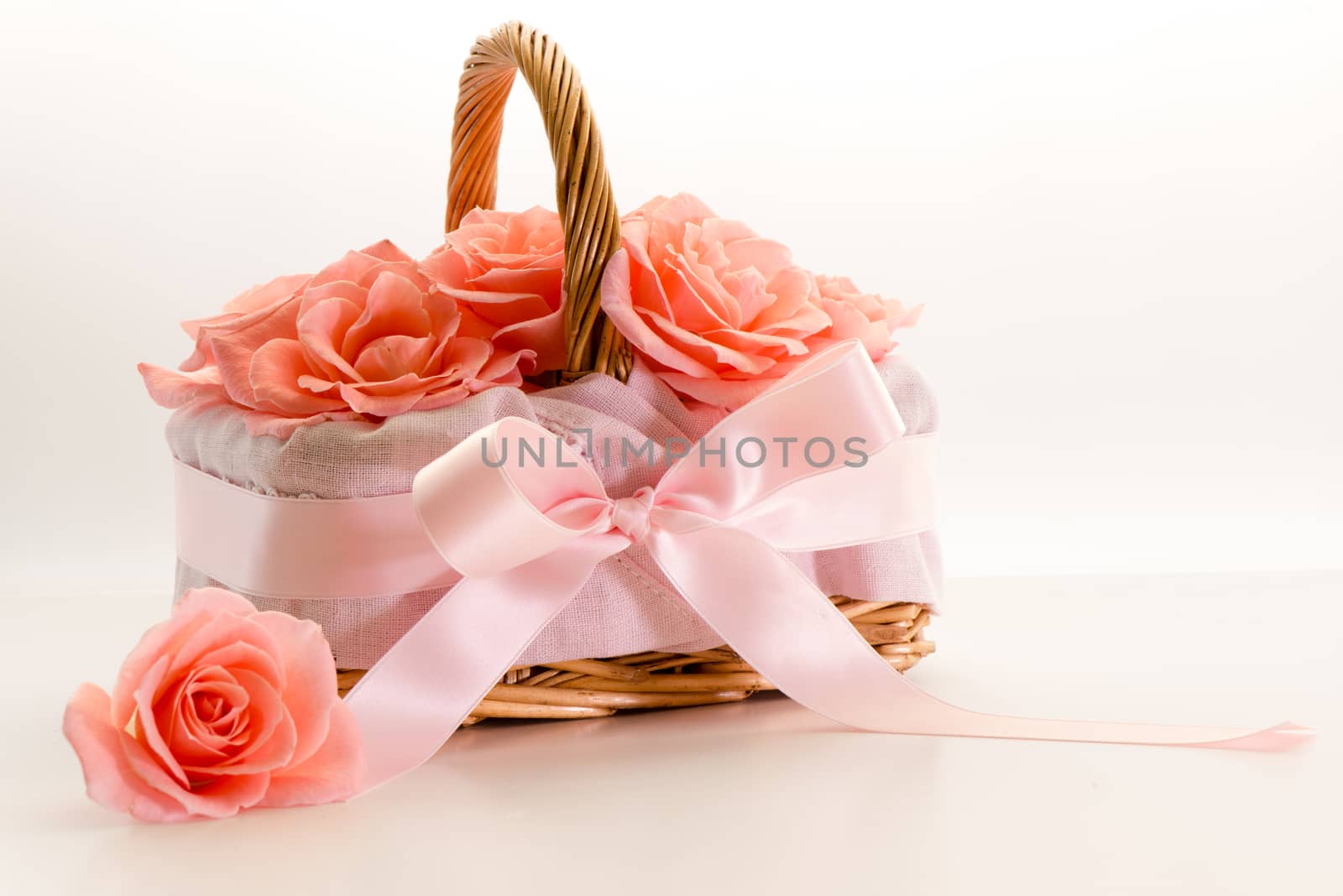 Roses in the basket with bow isolated on white background