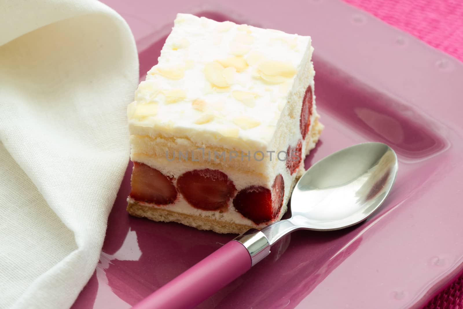 Dessert - sweet strawberry cake on pink plate and white napkin