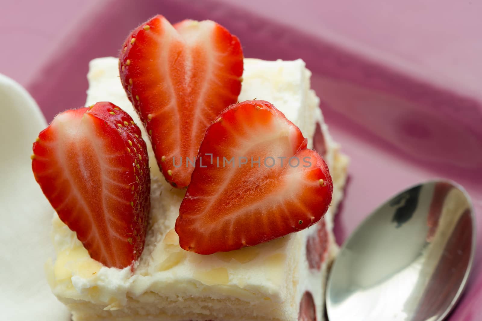 Dessert - sweet strawberry cake on pink plate and white napkin