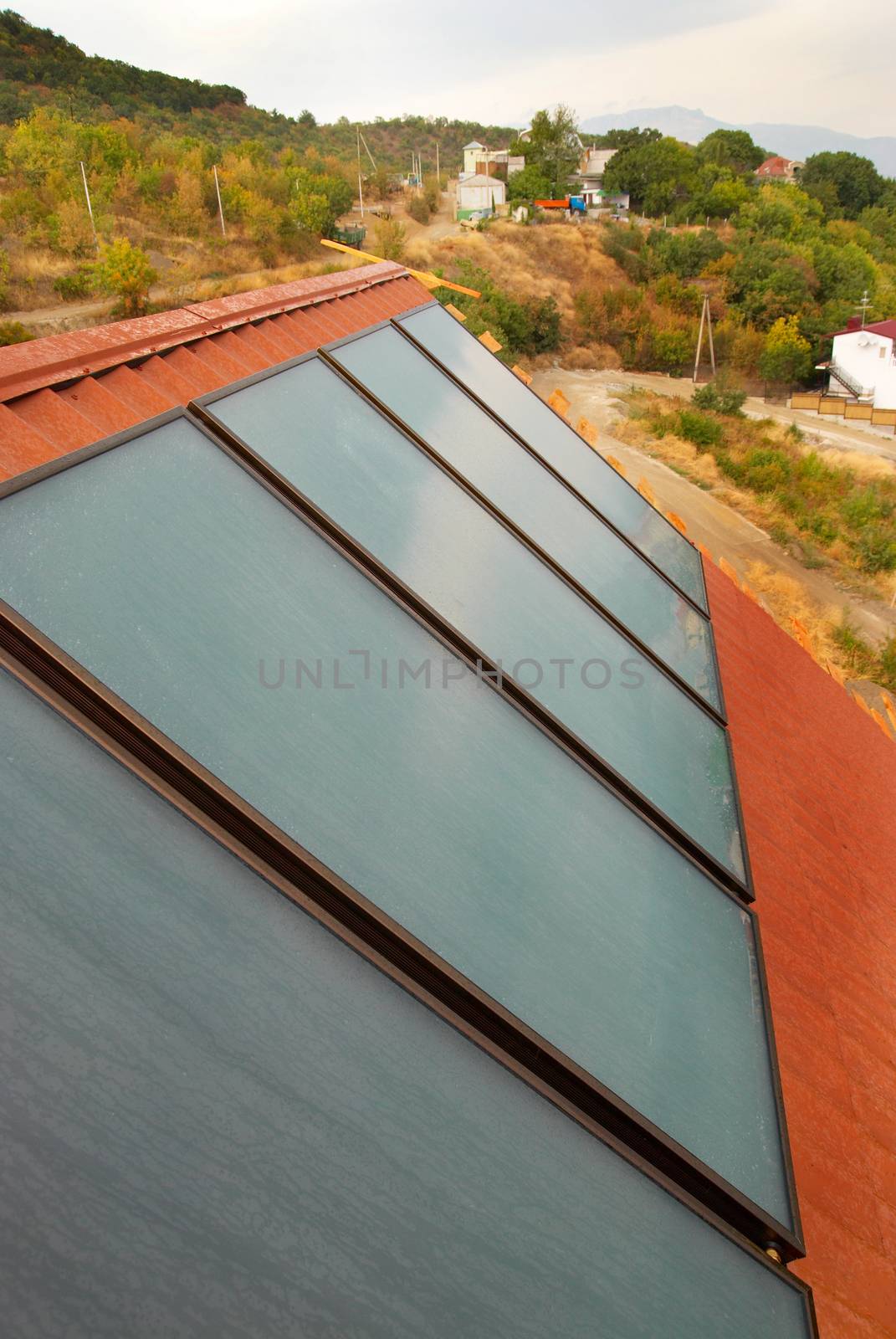 Solar water heating system (geliosystem) on the red house roof.