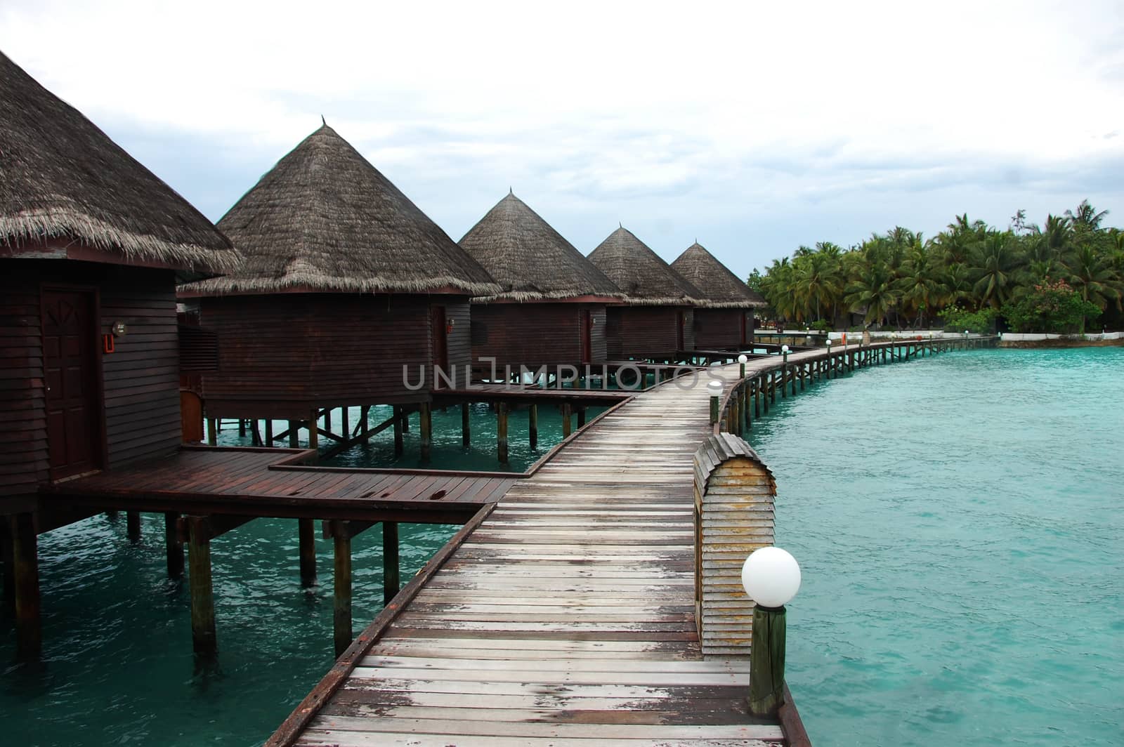 Bungalow and timber pier at island resort Maldives by danemo