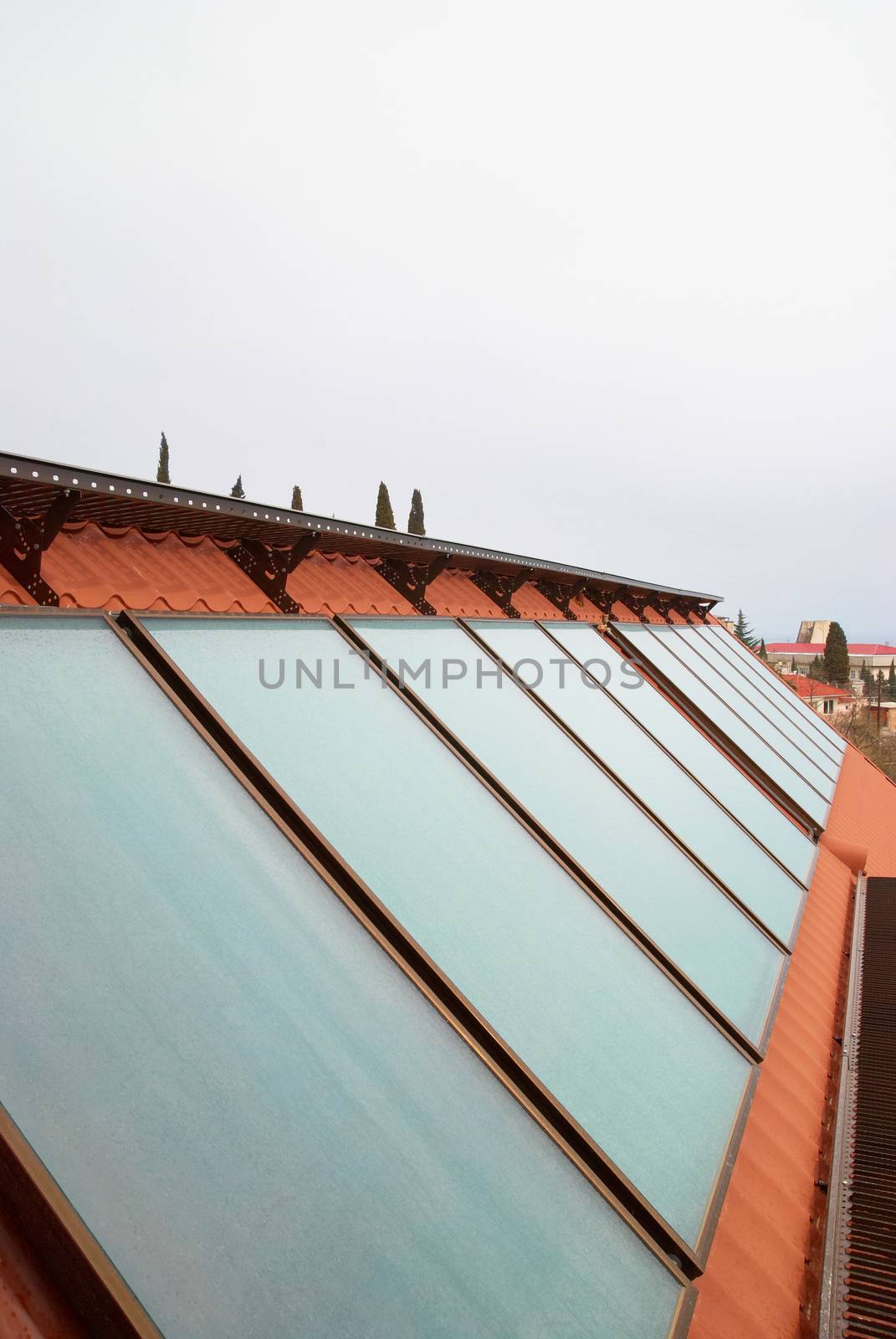 Solar water heating system (geliosystem) on the red house roof.