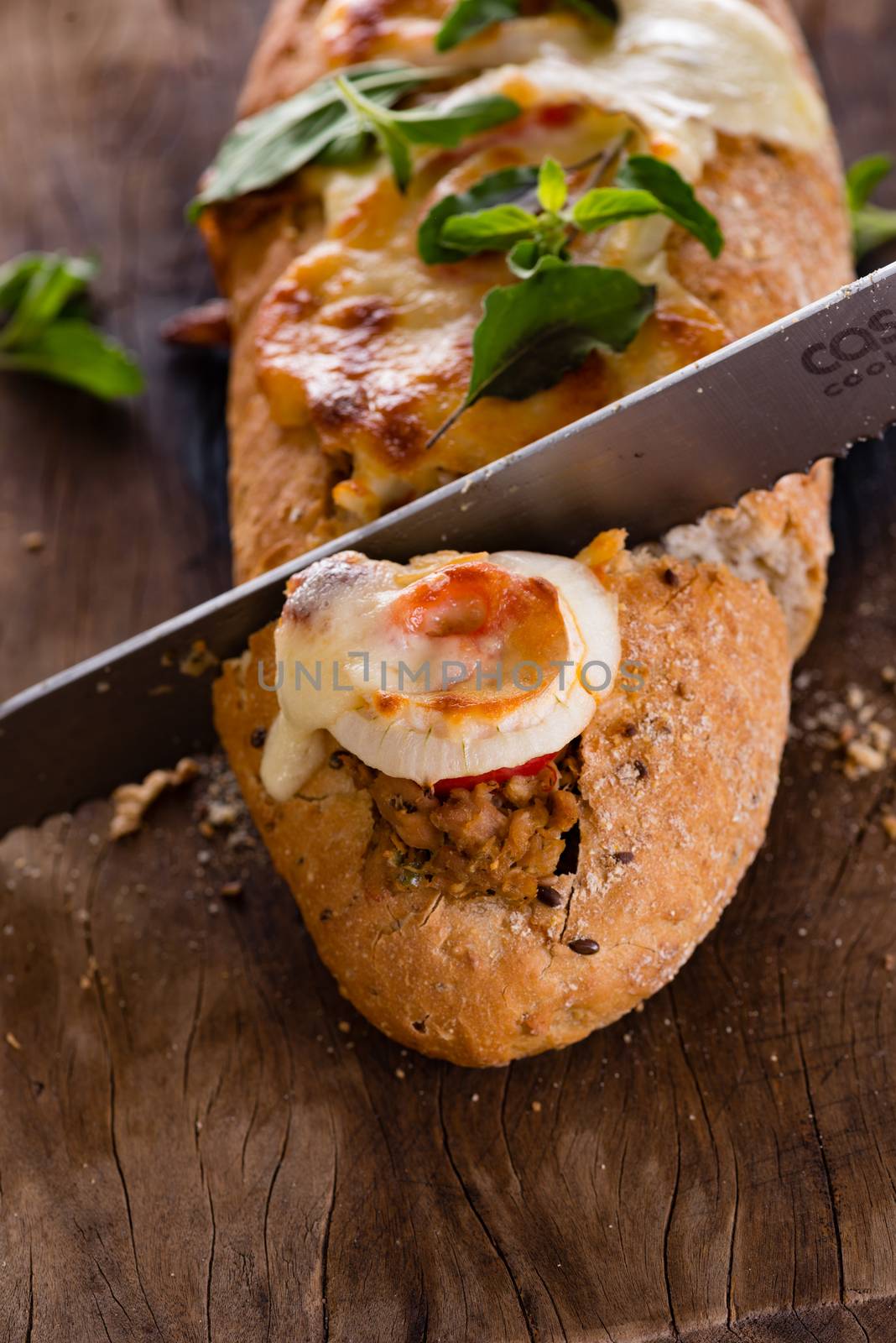 pizza baguette with mozzarella onion and tuna decorated with basil leafs