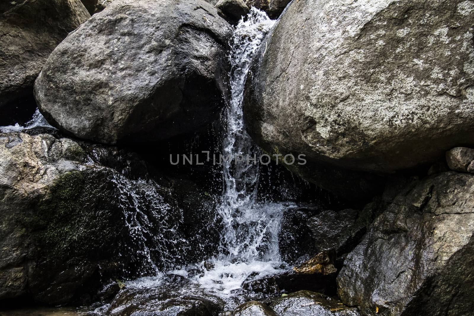 Water flowing down rocks by chingraph