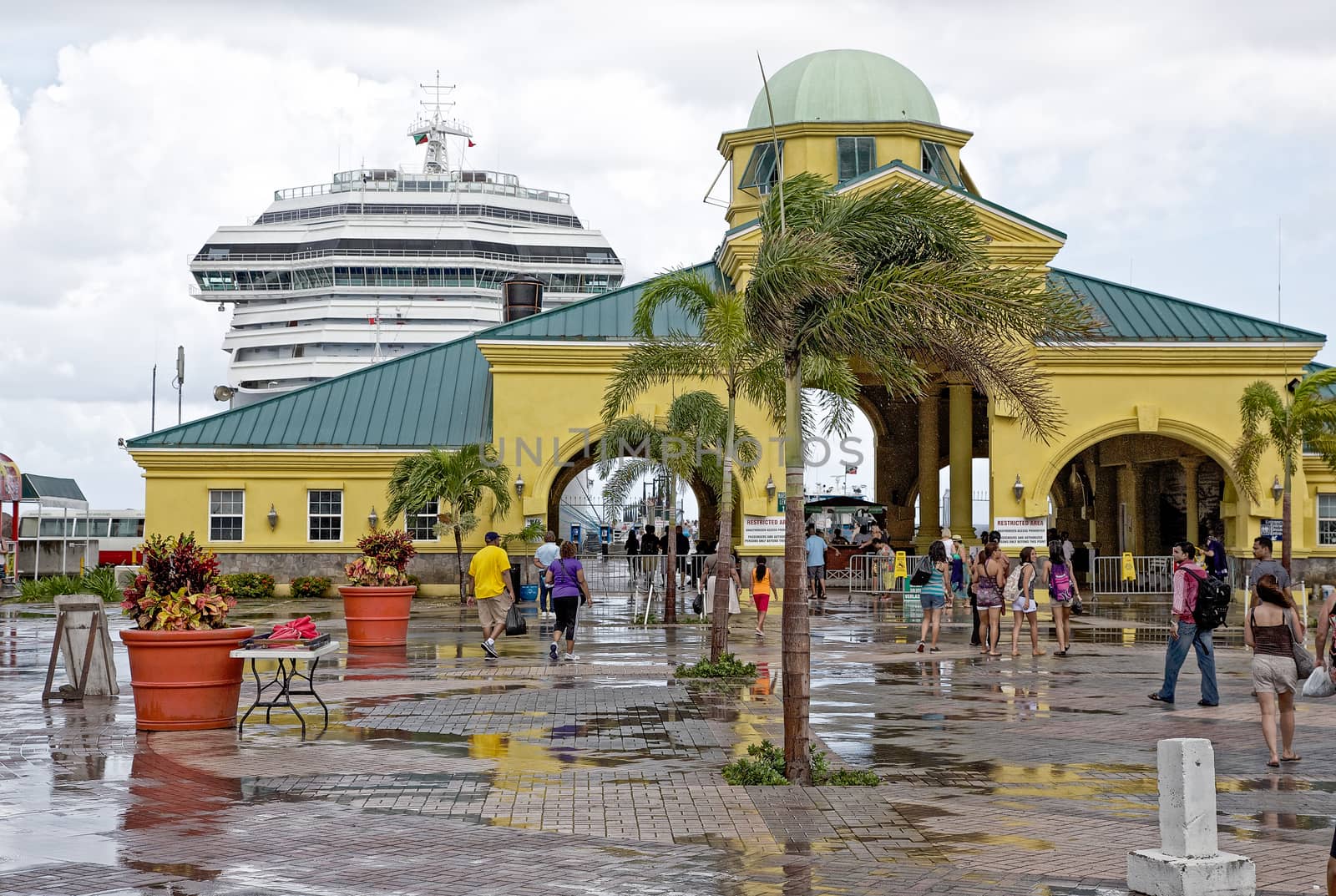 Basseterre, Saint Kitts and Nevis- June 21, 2013: Cruise ship passengers head back through the arches at Port Zante after a large downpour on this small Caribbean island.