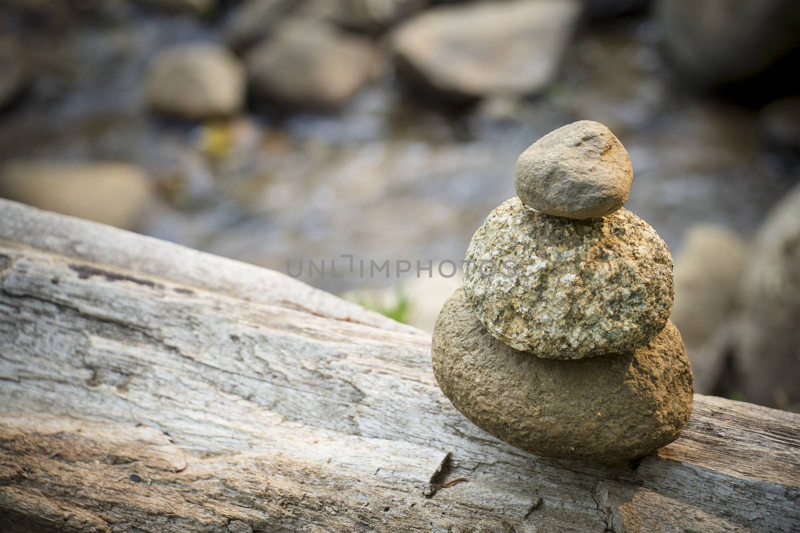 Zen stone over a running stream background by chingraph