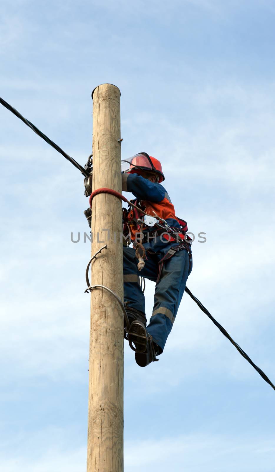 electrician installs insulated wire for electric main by AleksandrN