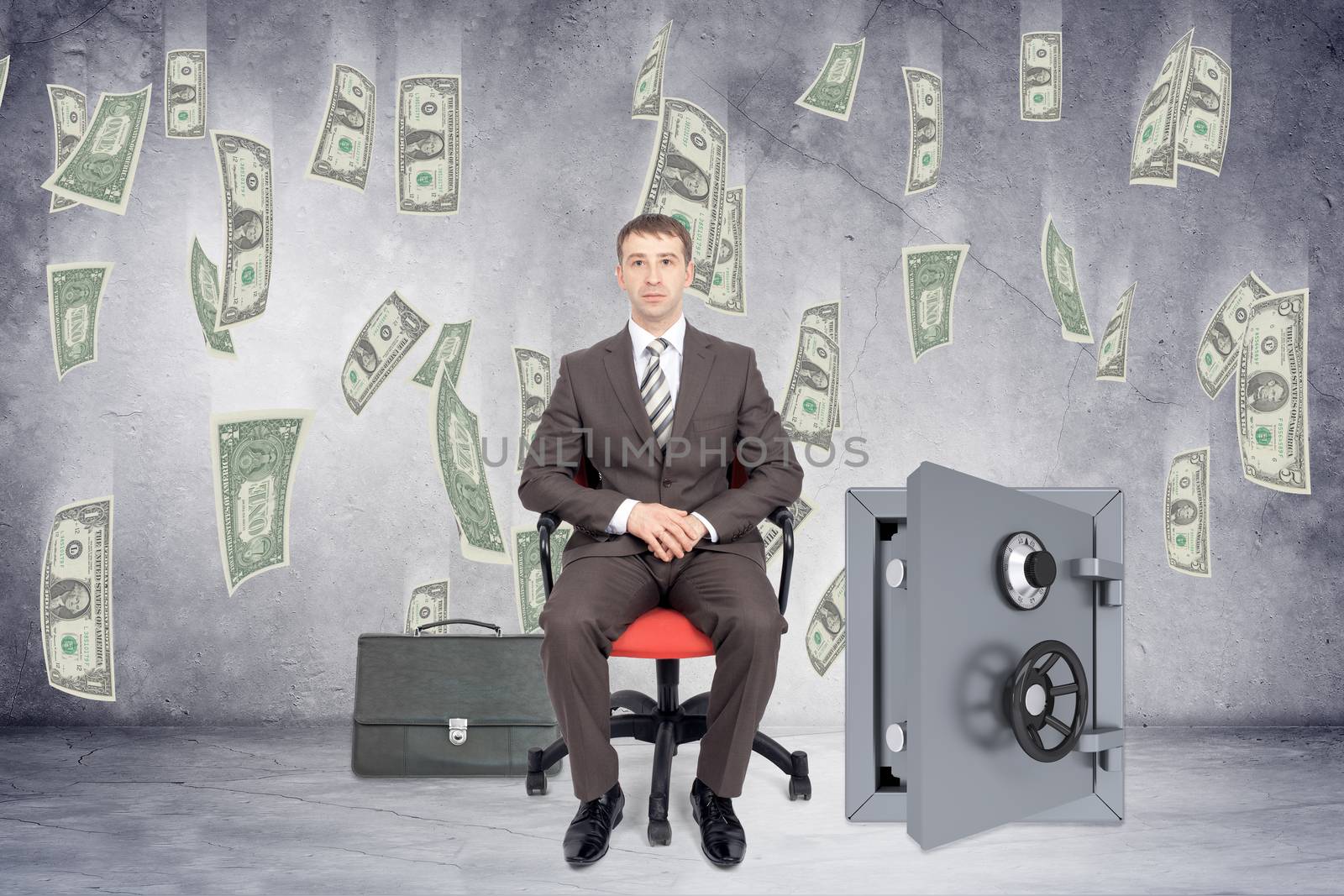 Businessman sitting in chair with open safe and money rain