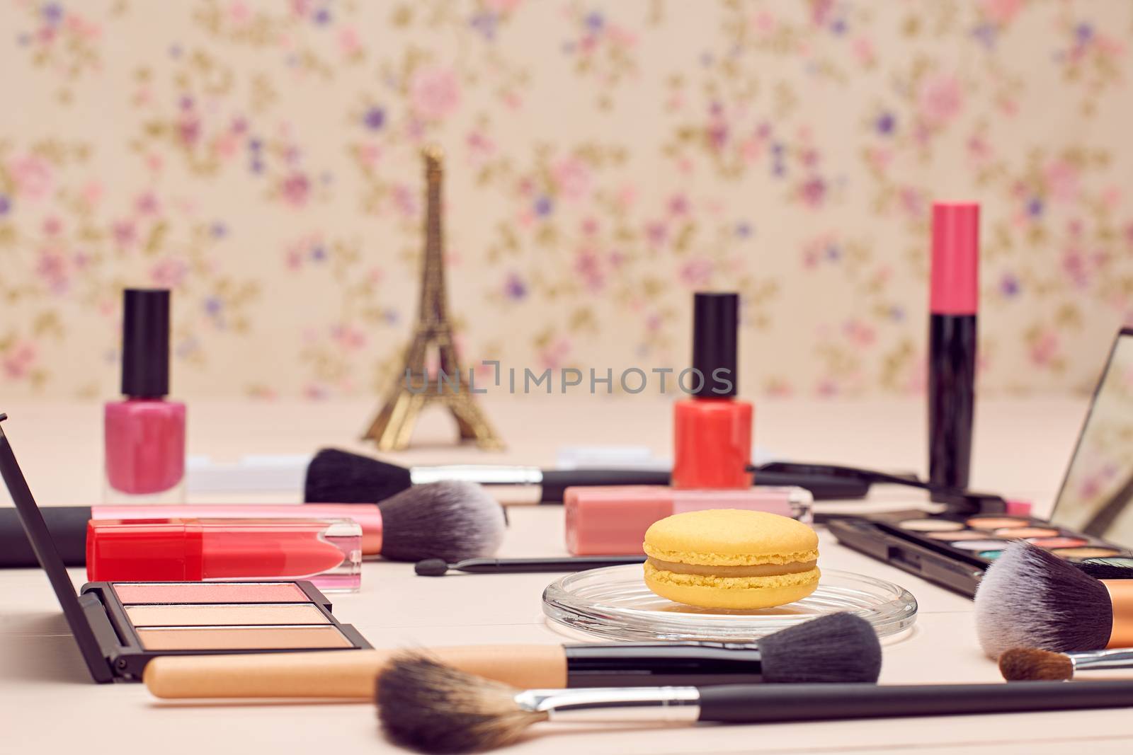 Still life, fashion woman essentials cosmetics. Beauty makeup accessories. Macarons french dessert. Lipstick, brushes, eyeshadow, false eyelashes, mascara.Unusual creative set. Vanilla wood background