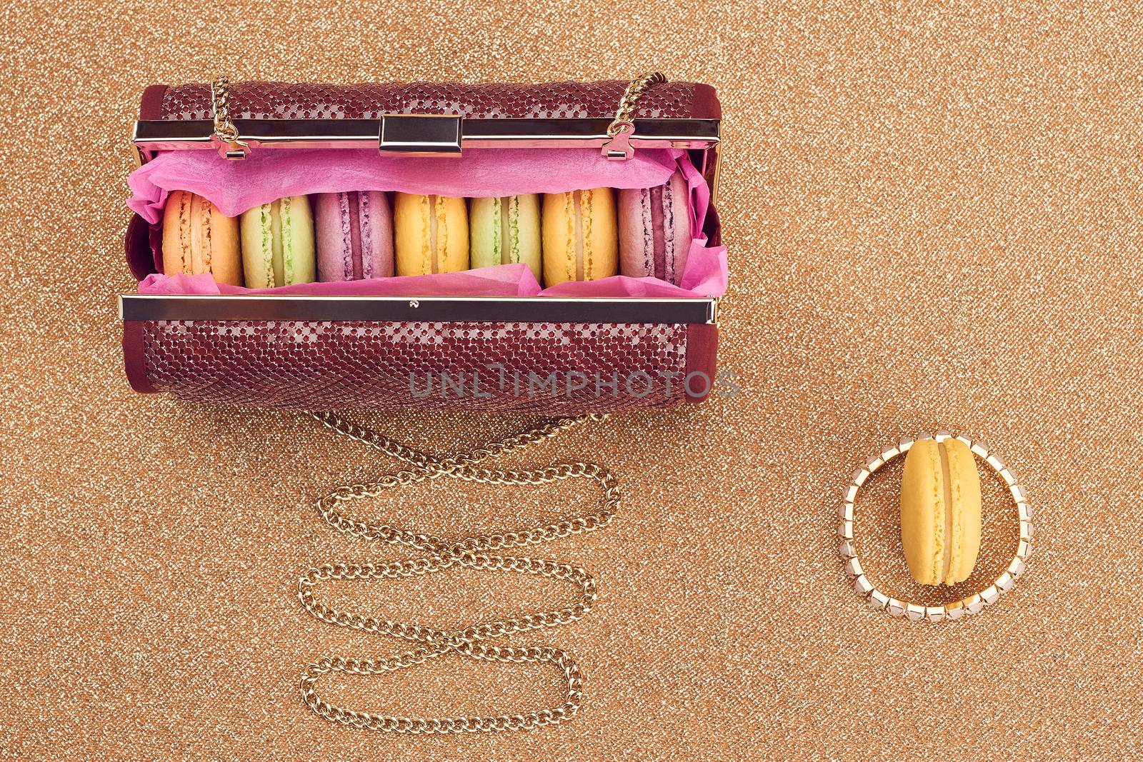 Macarons french in handbag. Luxury shiny glamor fashion clutch. Sweet colorful dessert. Unusual creative art, gold party background, bokeh, copyspase. Vintage