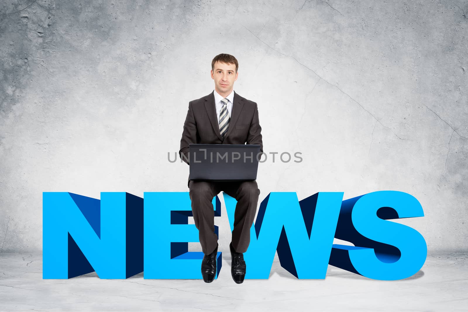 Businessman working on laptop and sitting on word news on grey wall background