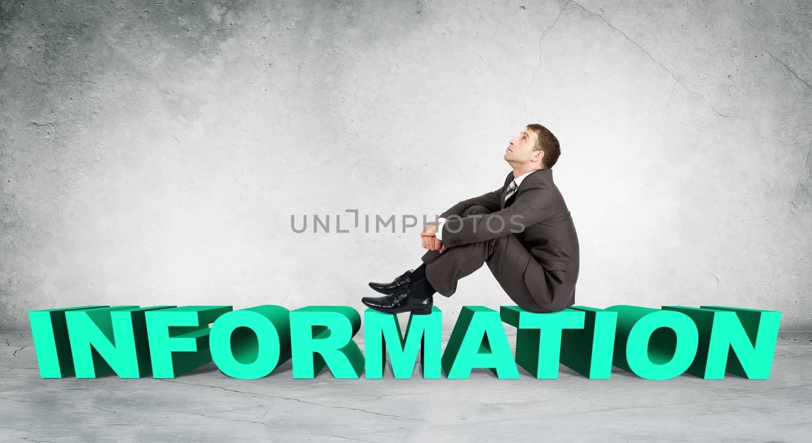 Businessman sitting on word information on grey wall background