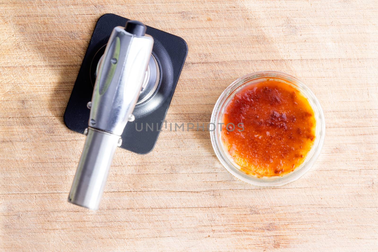 Freshly made creme brulee with a butane torch by coskun