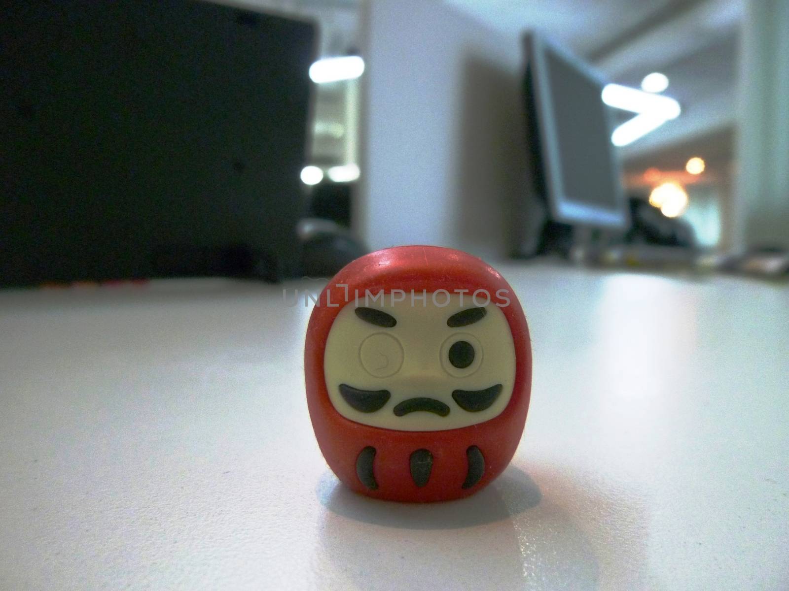 The prayer rubber of Red Janpanese doll Daruma on the table