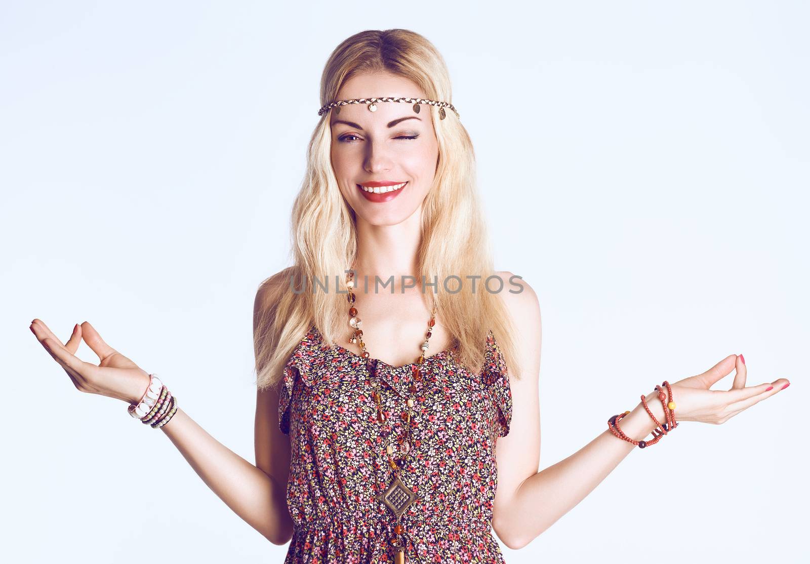 Beauty woman doing yoga, smiling and wink. Boho hippie girl meditates, enjoying calm, relax and harmony, ethnic accessories. Positive blonde, long hair in floral sundress. Unusual creative, people