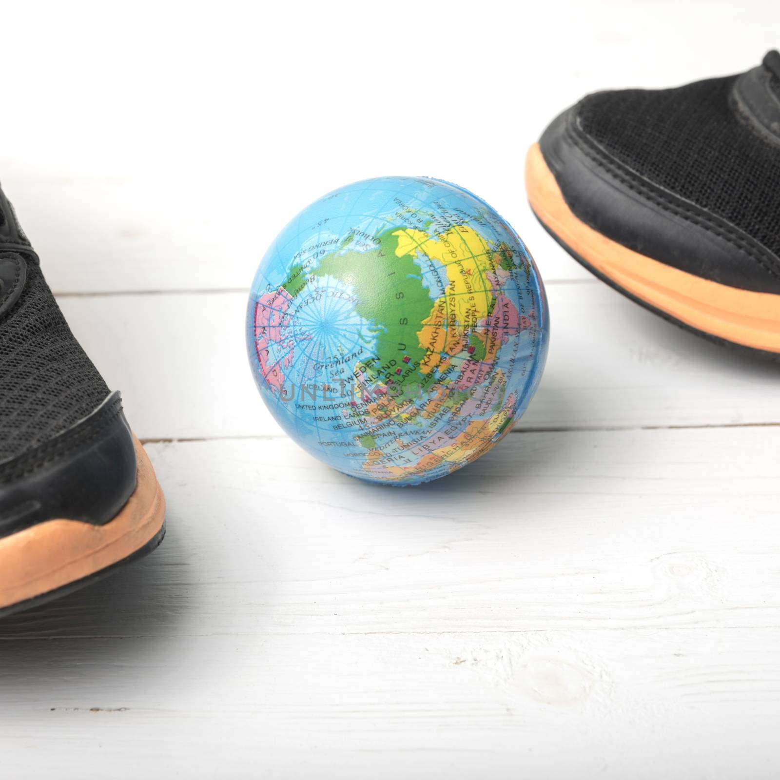running shoes and earth ball on white wood table concept world healthy