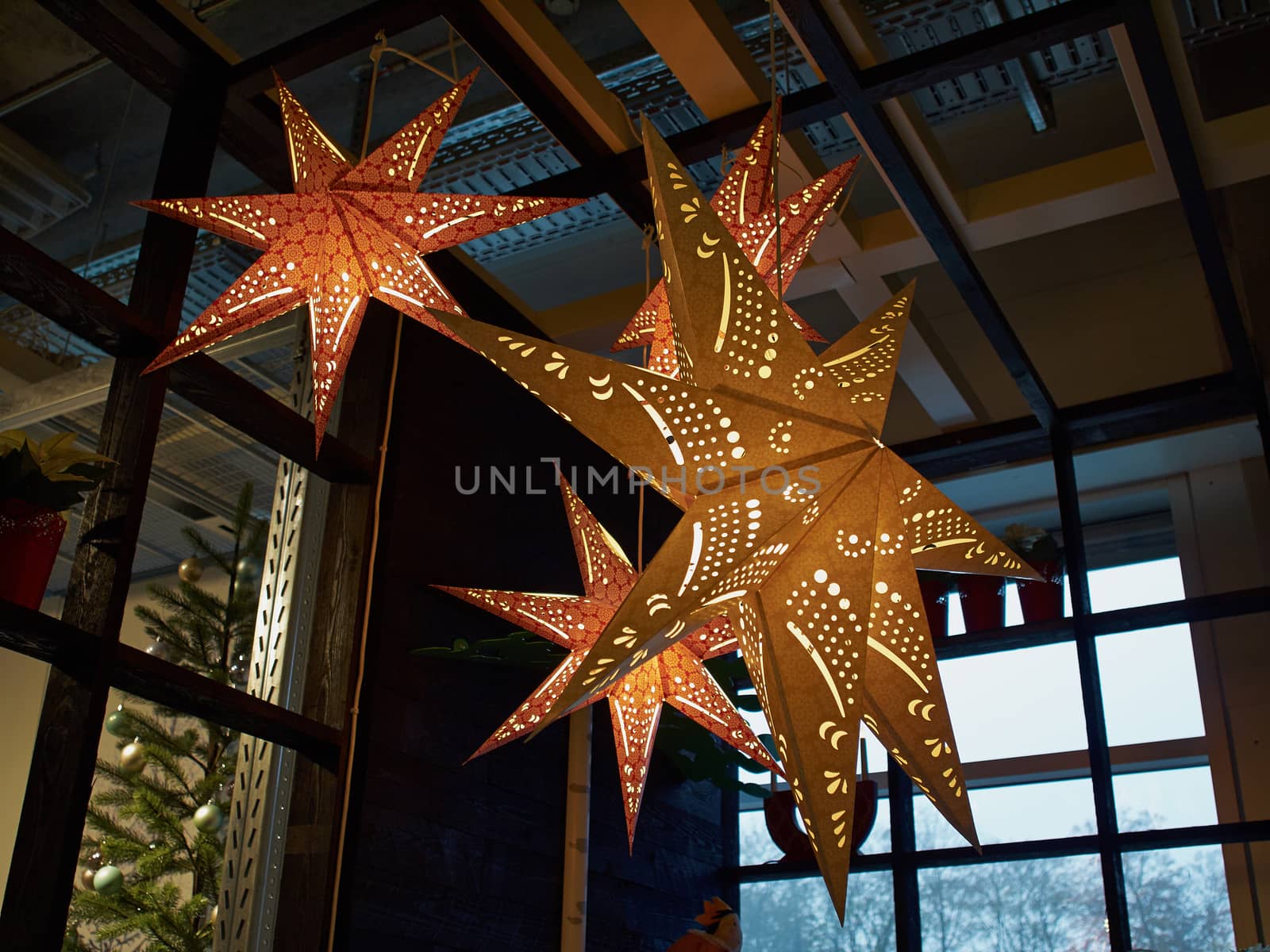Golden glittering star shaped Christmas paper ornament hanged as festive decoration