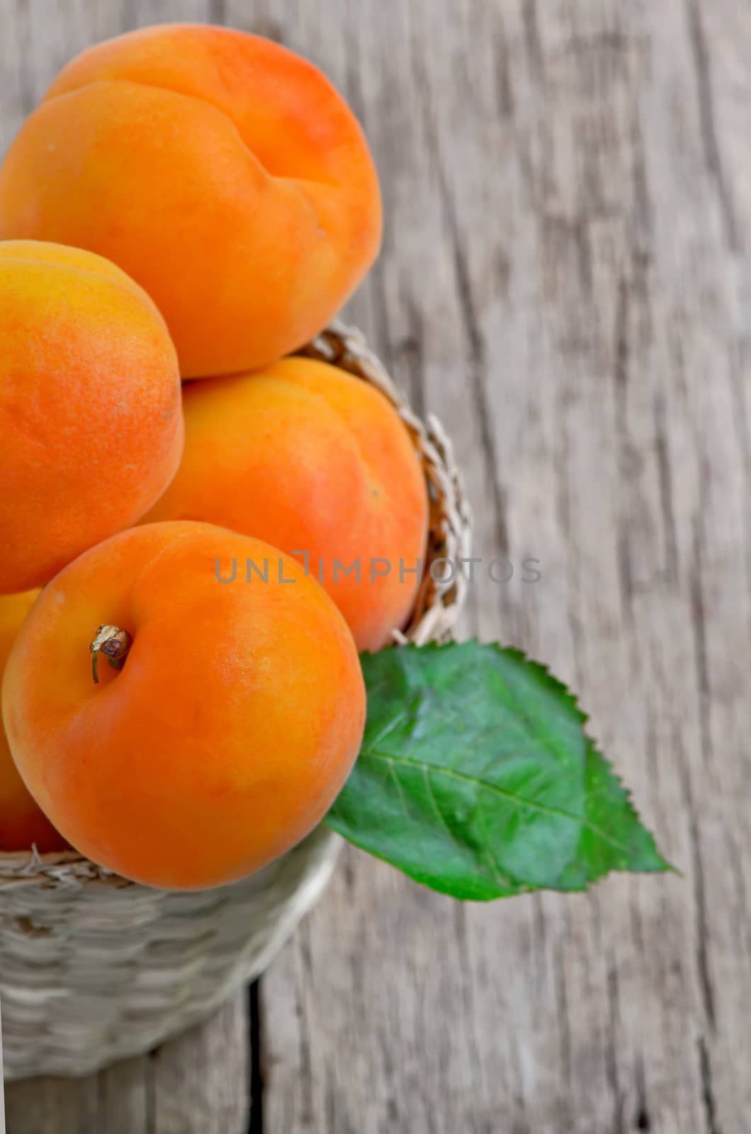 Fresh peaches in the basket on a wooden table