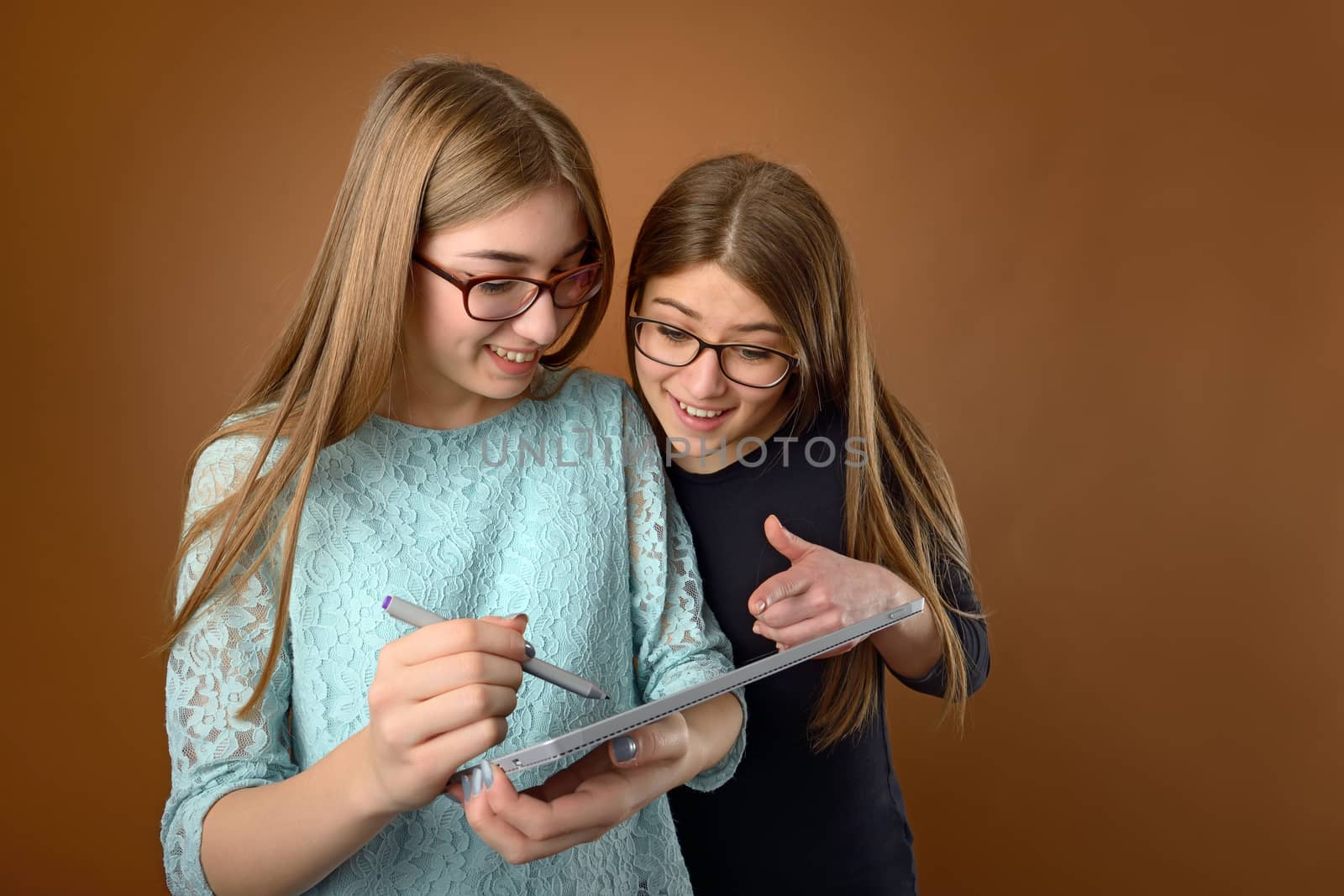 Two teen young friends using a computer tablet 