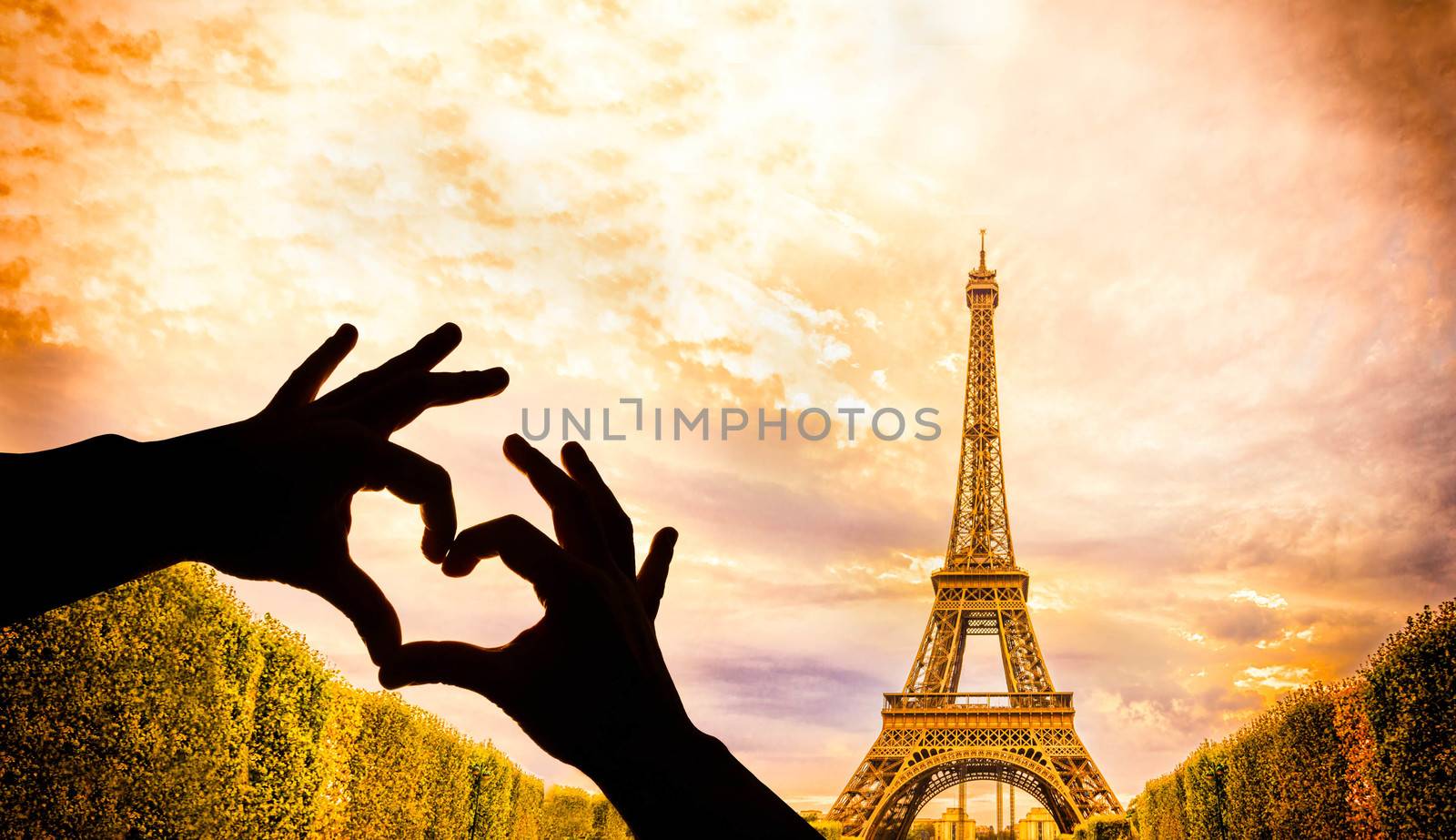 The Eiffel Tower in Paris and hands in a heart shape by gianliguori