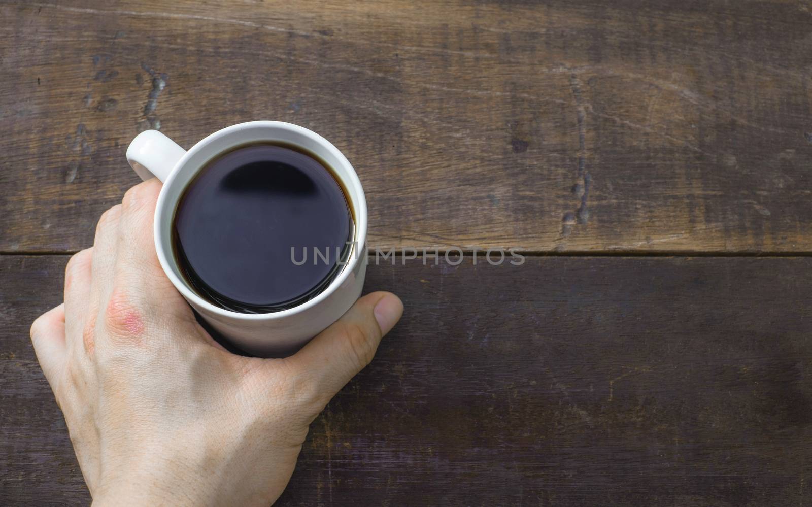 hot coffee in man hand on wood table