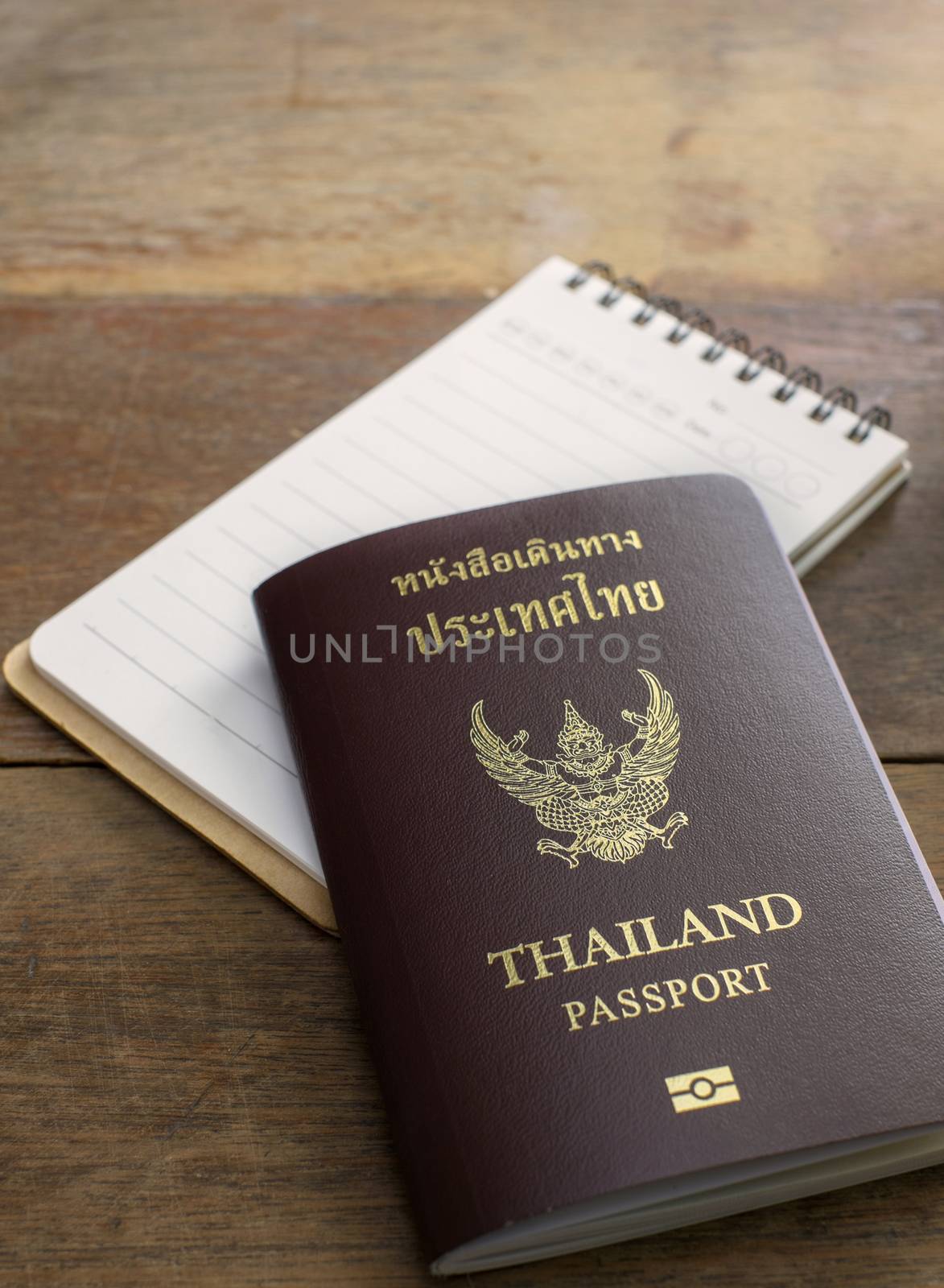 thai passport and notebook on wood table
