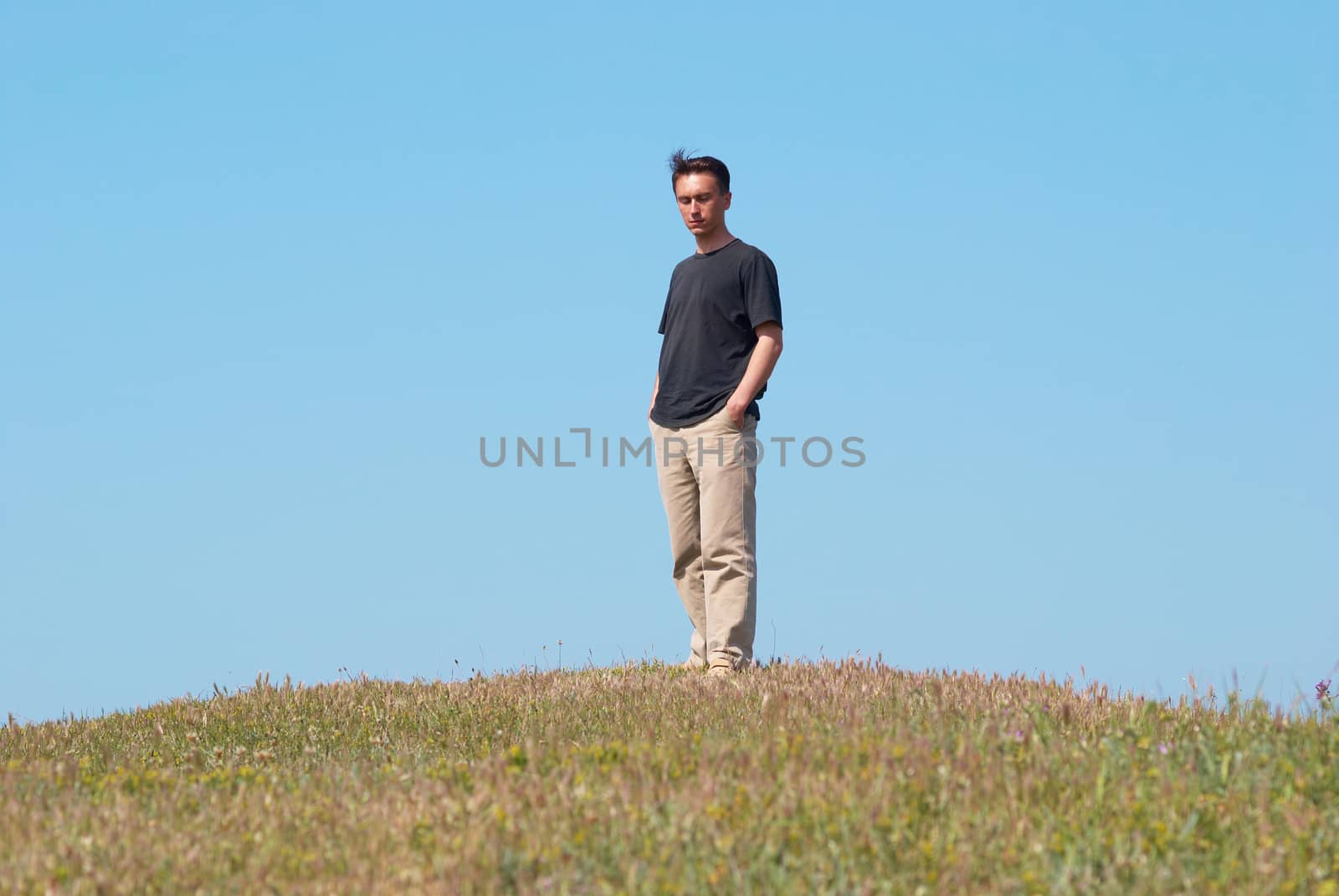Young man on the grass field with blue sky