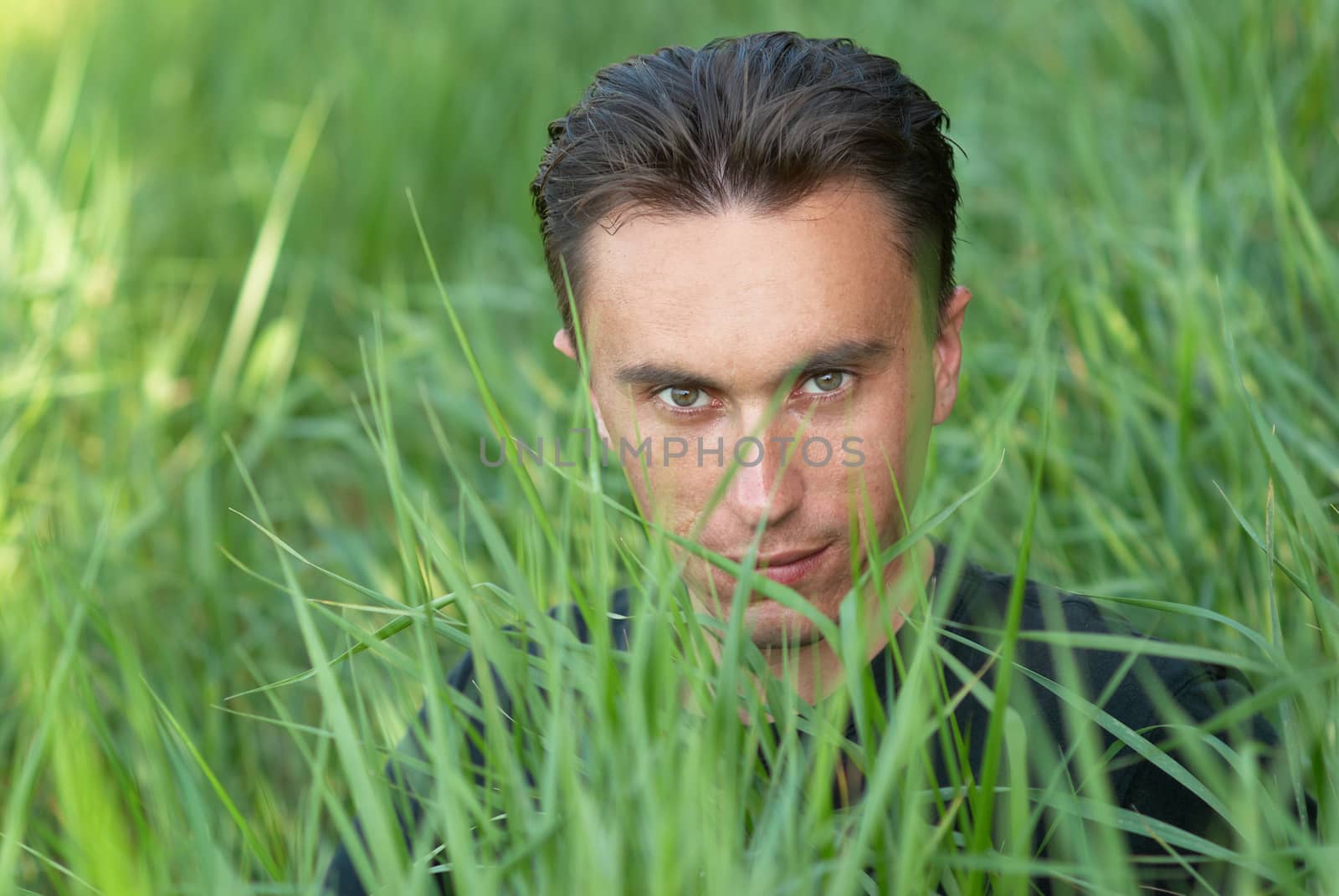 Man's portrait in the green grass background