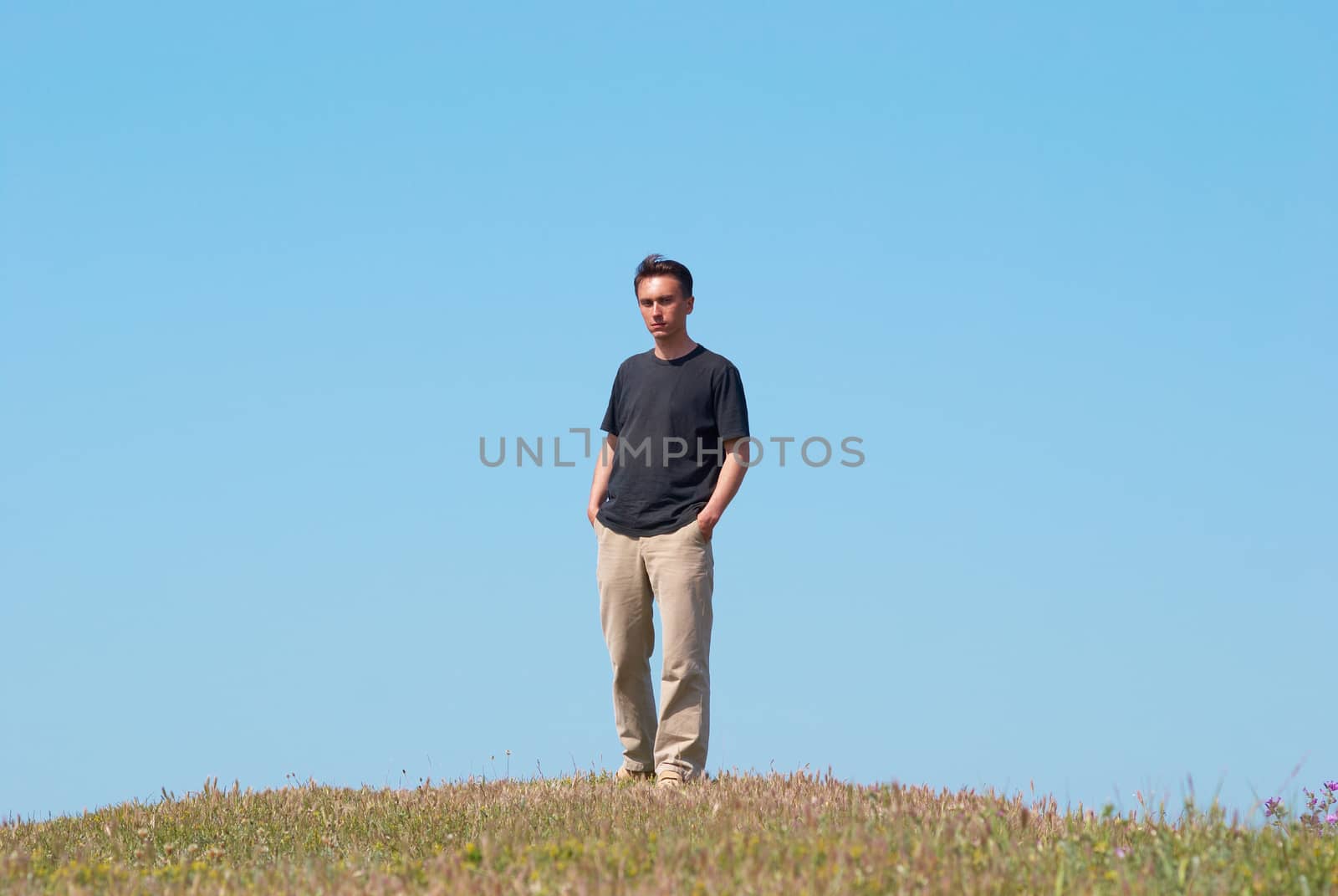 Young man on the grass field with blue sky