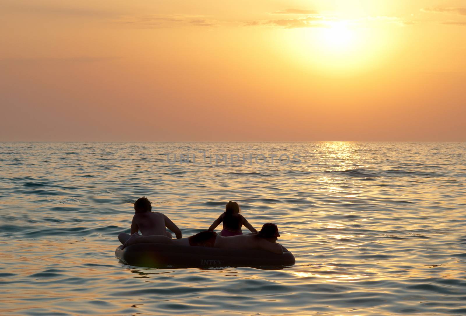 People on the raft with sea's sunset
