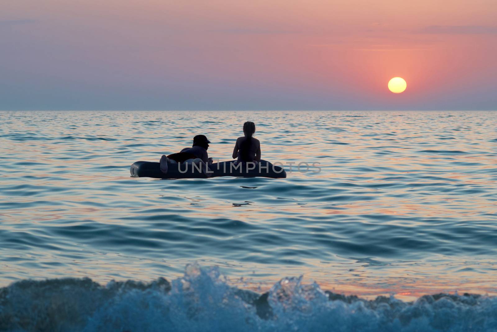 People on the raft with sea's sunset