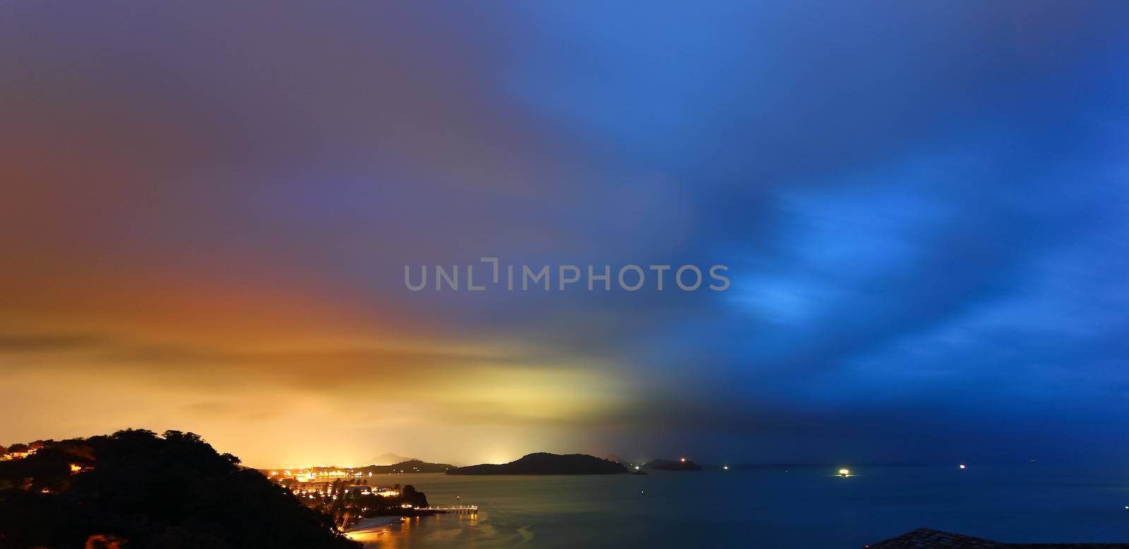 Twilight sky above the sea and light from the shore.