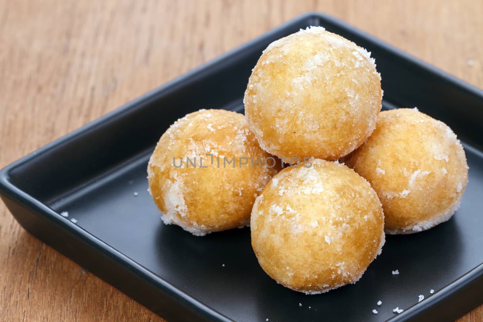 Crisp sweet rice ball made from sticky rice on black plate
