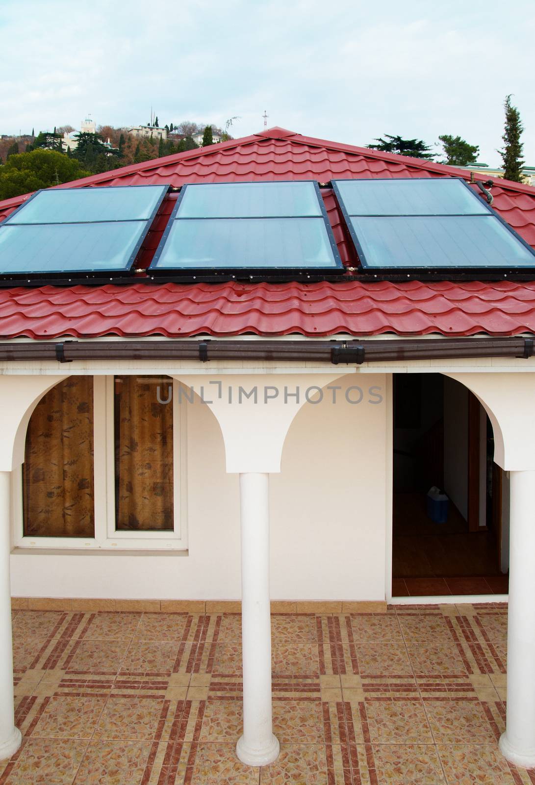 Solar water heating system (geliosystem) on the red house roof.