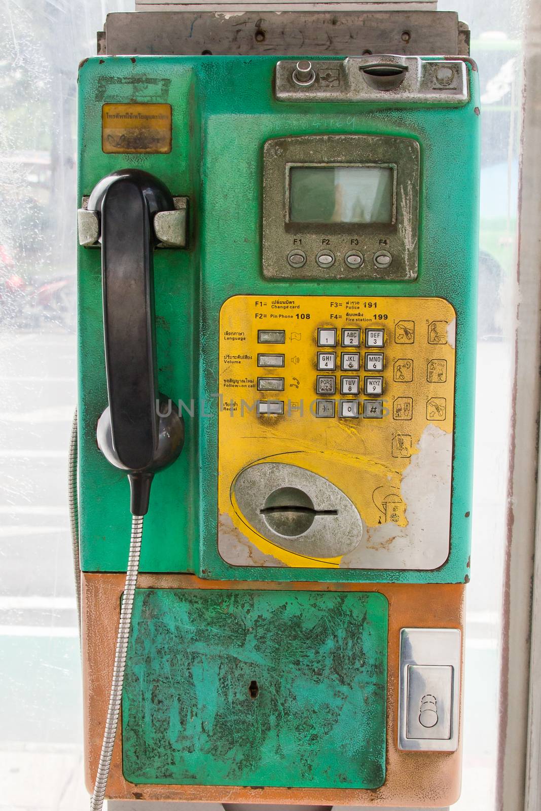 Thai old public phone that say on the left panel 'For coins or card use'.