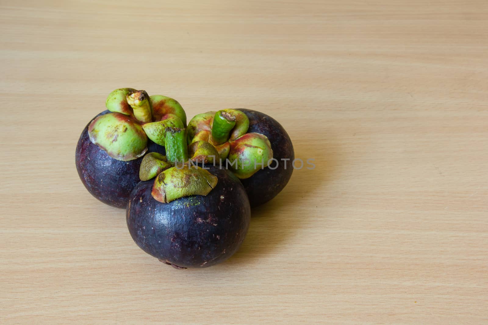 Fresh mangosteen place on a wooden table.