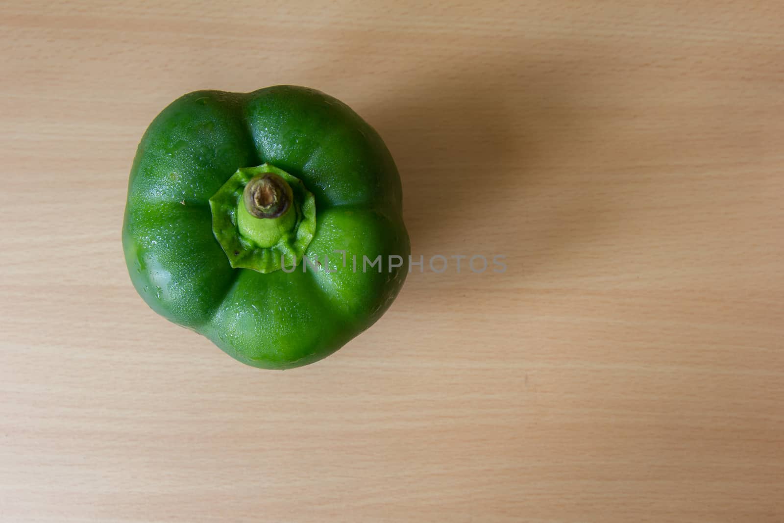 Green pepper on the wooden desk