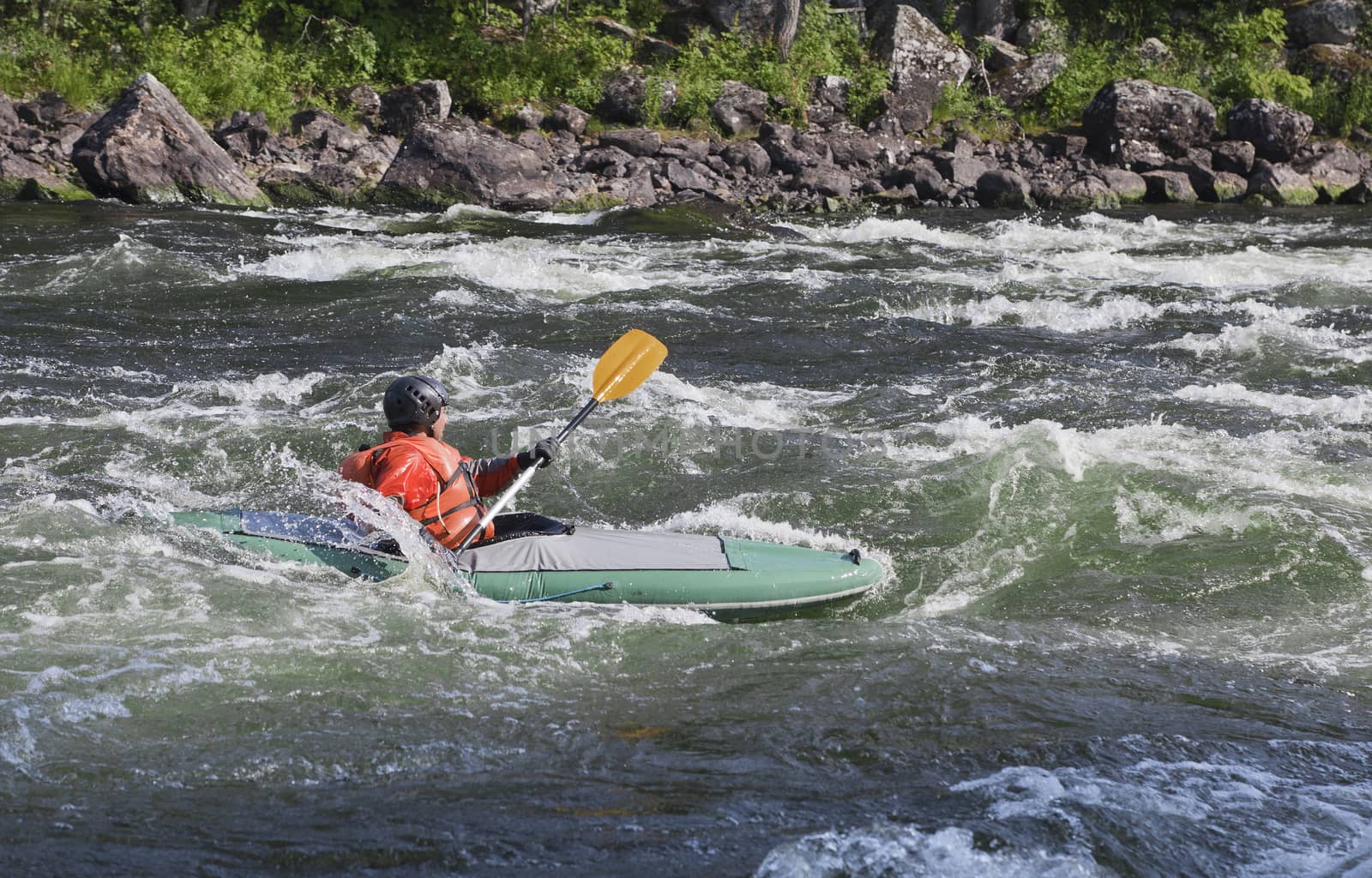 Kayaker in the  whitewater of a river Umba in Russia